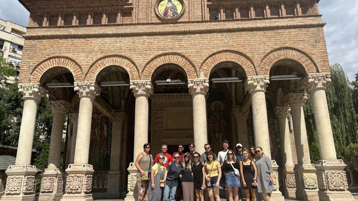 ASU students in the Romanian study abroad program pose for a group photo on the steps of a building.